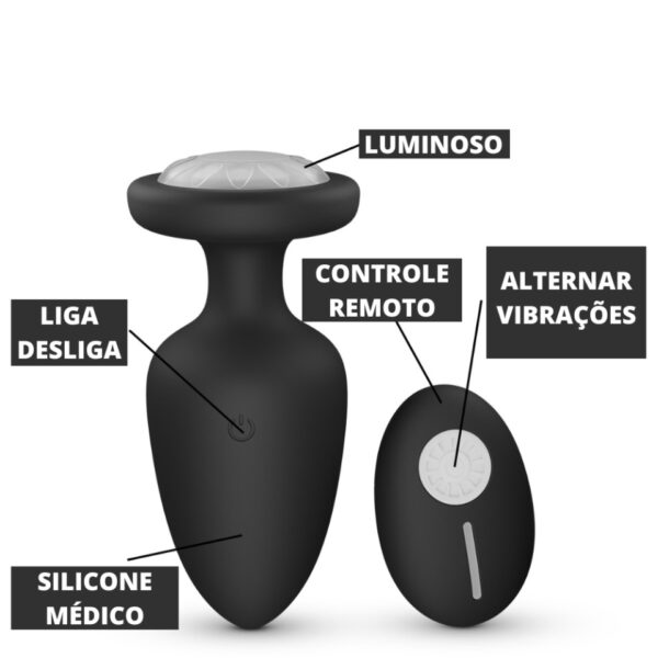 plug anal com controle remoto e base luminosa com cores do arco irís na cor preta com escritas: luminoso, controle remoto, alternar vibrações, liga e desliga, silicone médico